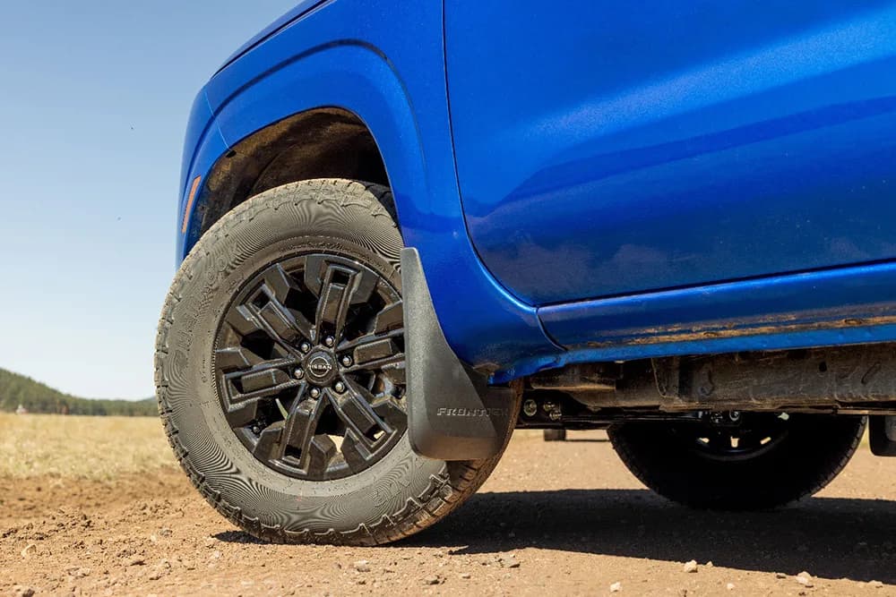 The wheel well of a blue car