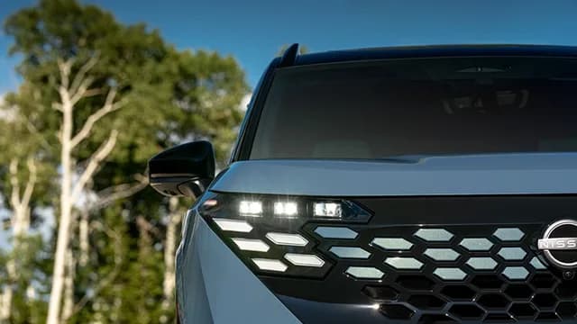 Close up of the front left headlight and grille on the 2027 Nissan Rogue Hybrid Platinum.