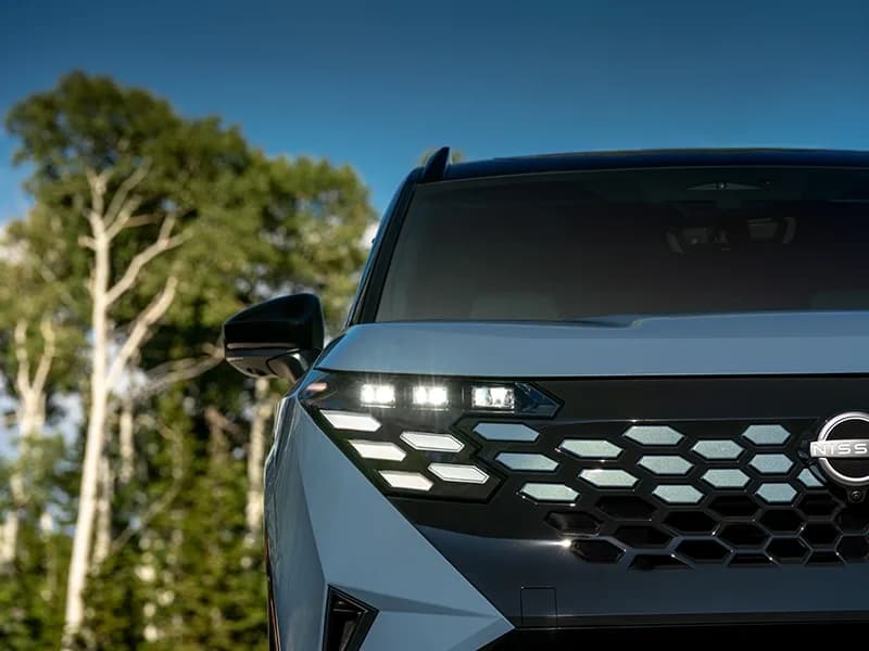 Close up of the front left headlight and grille on the 2027 Nissan Rogue Hybrid Platinum.