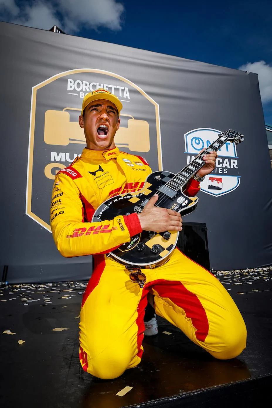 Winner #10: Alex Palou, Chip Ganassi Racing Honda celebrates with his Gibson guitar trophy  on the podium