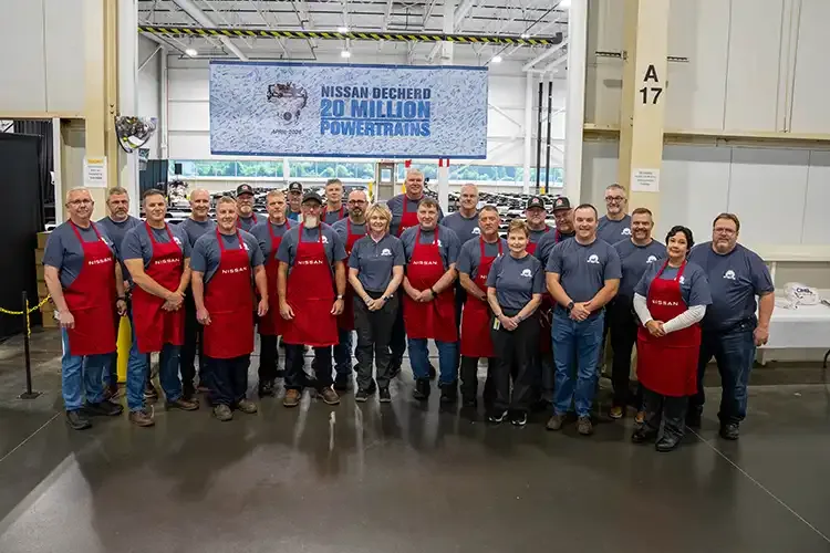 A large group of Nissan employees standing together got a photo, a banner that reads