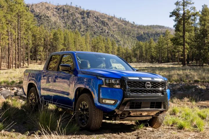 Front right 3/4 view of the 2027 Nissan Frontier Sport Edition parked in a wooded area.